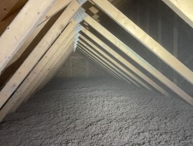 Grey cellulose insulation in a ceiling
